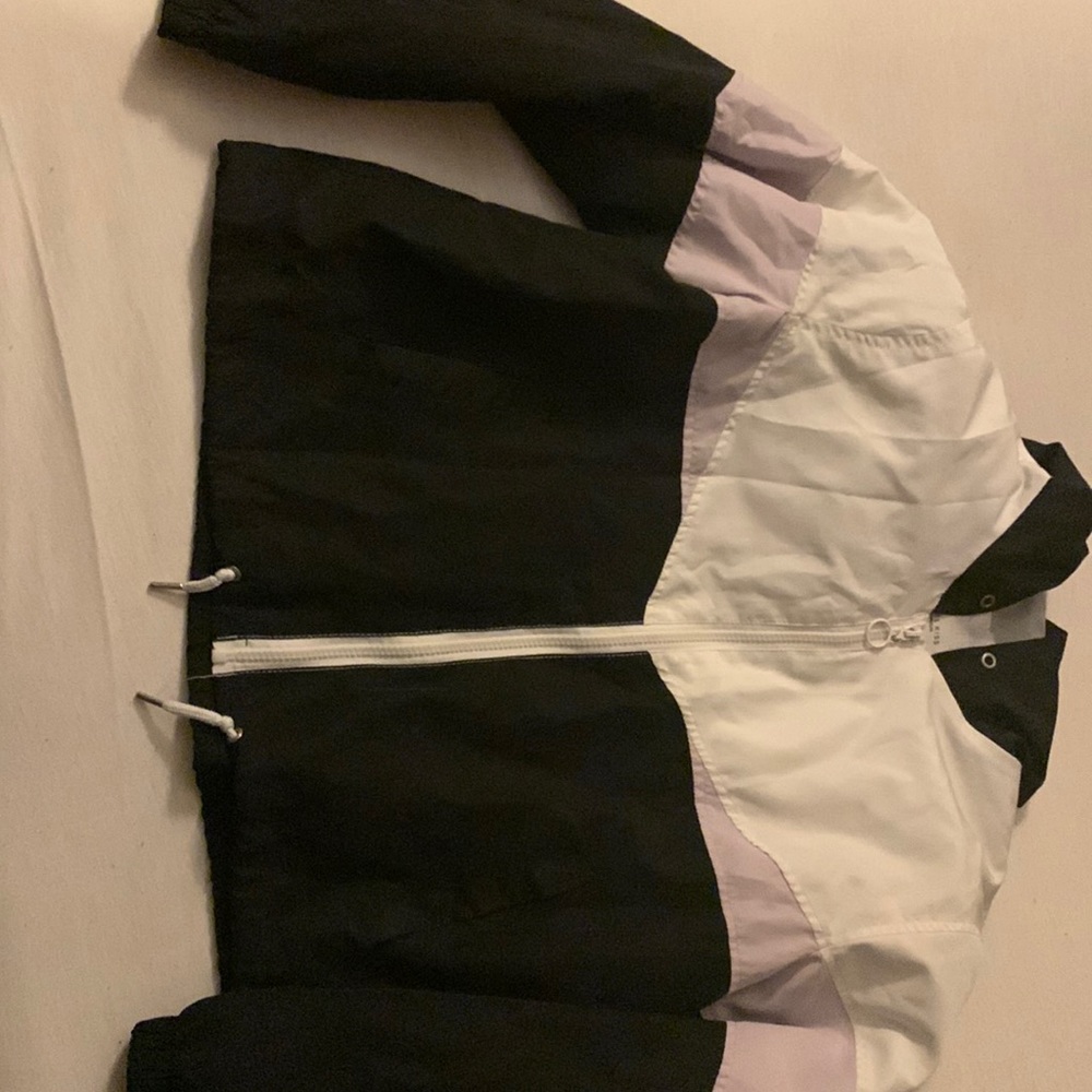 A multi colored windbreaker for big kids sized Medium